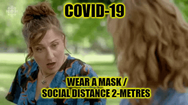 a woman is wearing a mask and talking to another woman