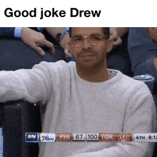 a man wearing glasses is sitting in a stadium with the words good joke drew on the top