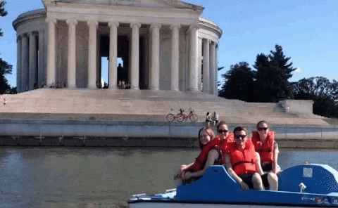 a group of people on a boat in front of a temple