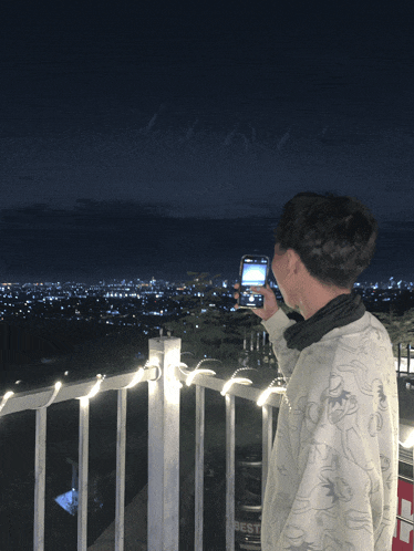 a man taking a picture of a city with his phone