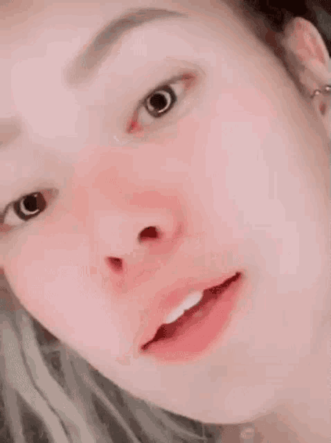 a close up of a woman 's face with her eyes closed and a red cheek .