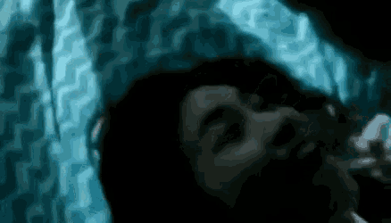 a close up of a person laying in bed with their mouth open .