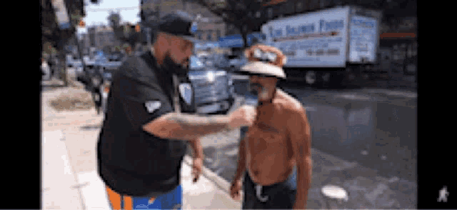 a man talking to another man on the sidewalk with a truck in the background that says the island farm