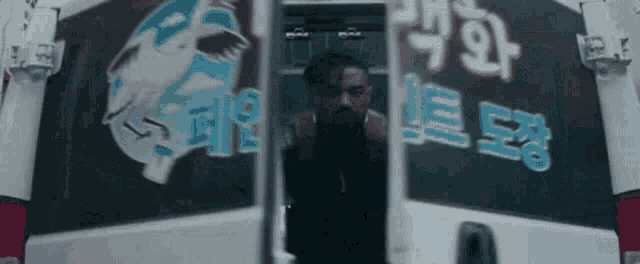 a man is standing in the back of a white van with a fish on the back .