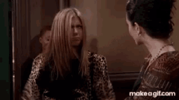 two women are giving each other a high five while standing next to each other .