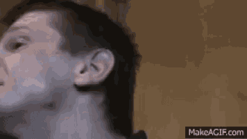 a close up of a man 's face with a slight smirk on his face .