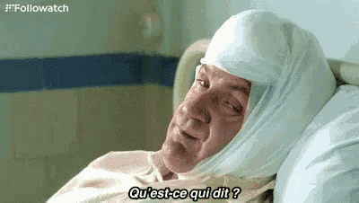 a man is laying in a hospital bed with a bandaged head .