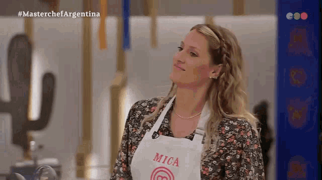 a woman wearing an apron with mica written on it