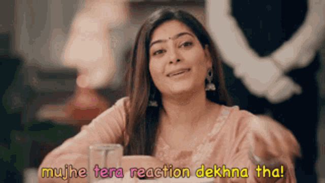 a woman sitting at a table with a glass of water and a caption that says ' muje tera reaction dekha tha '