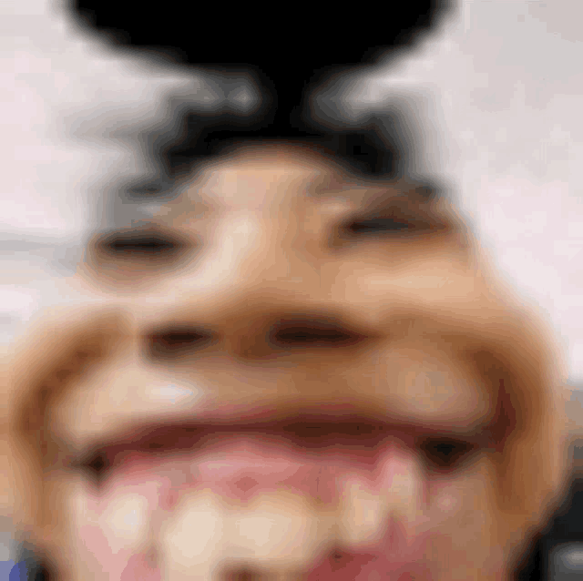 a close up of a person 's face with a blurred background and their mouth open .