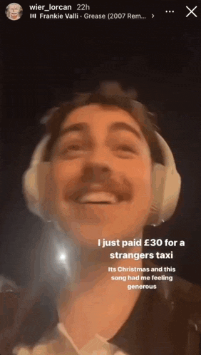 a man wearing headphones and a mustache is smiling and talking .