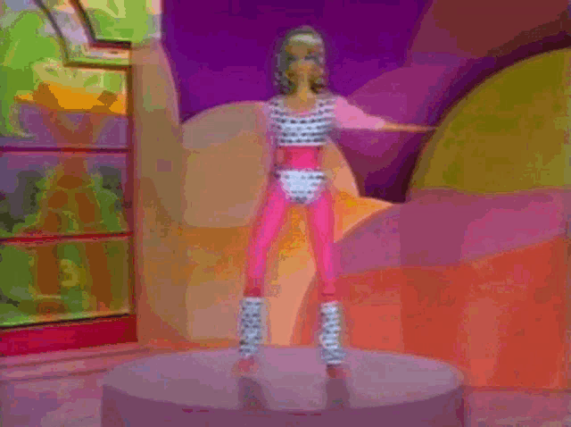 a barbie doll is standing on a pedestal wearing a pink outfit