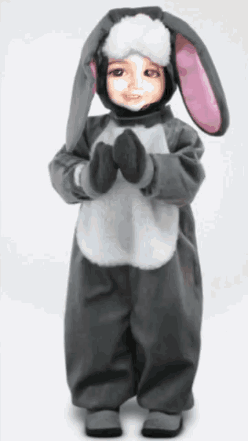 a child dressed in a bunny costume is standing with his arms crossed