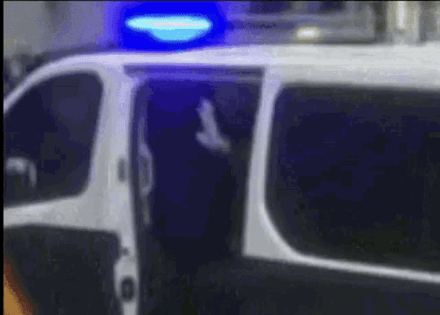 a police van with a blue light on the top of it .