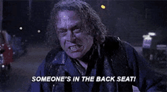 a man is crying in the back seat of a car .
