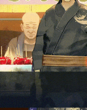 a man in a kimono stands in front of a display of candy apples