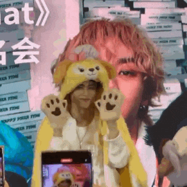 a person wearing a teddy bear hat is holding a phone
