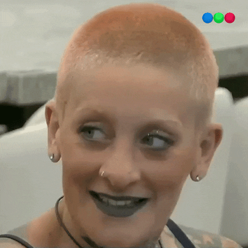 a close up of a woman 's face with a very short haircut