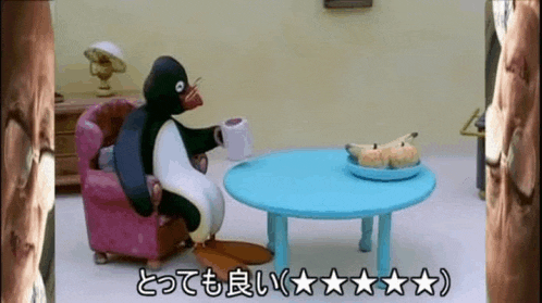 a penguin is sitting in a chair with a cup of coffee and a plate of bananas on the table .
