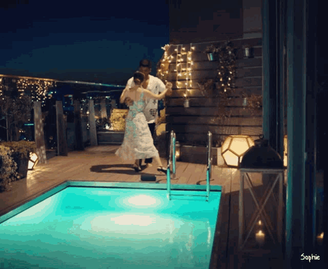 a man and a woman are dancing in a swimming pool with the name sophie on the bottom
