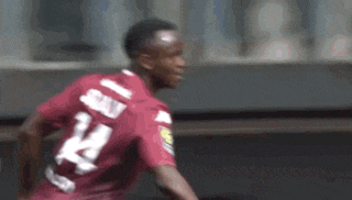 a soccer player wearing a red jersey with the number 24 on it is running on a field .
