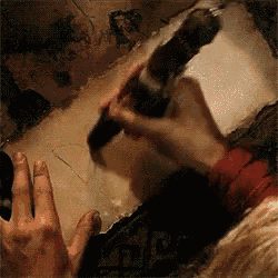 a close up of a person 's hand holding a hammer