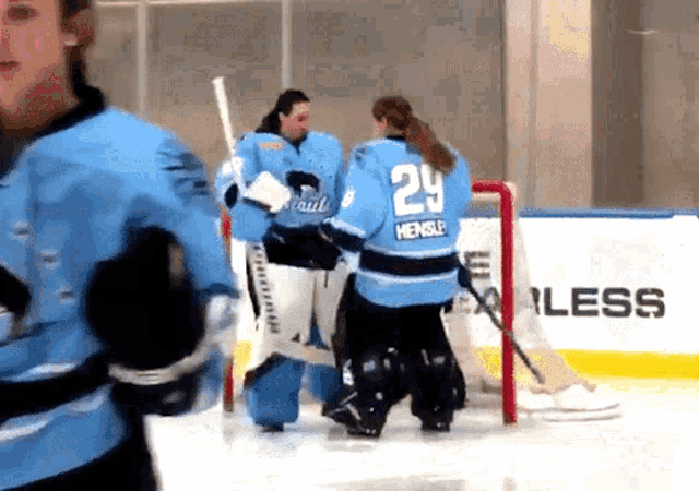 a female hockey player wearing a number 29 jersey