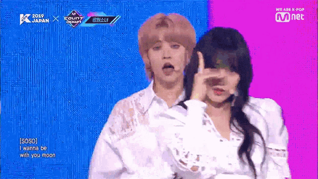 a man and a woman are standing next to each other on a stage and making funny faces .