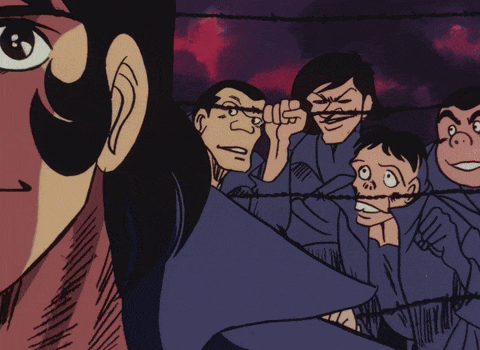a group of men are behind barbed wire and one of them is smiling