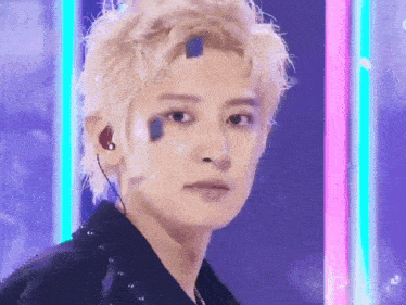 a close up of a person 's face with a blue sticker on his forehead