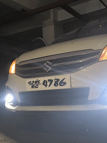 a white suzuki car with a license plate that says 4786