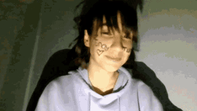 a girl with a drawing of a heart on her face and the word may on her face