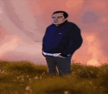 a man in a blue jacket is standing in a field