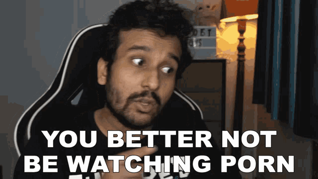 a man sitting in a chair with the words you better not be watching porn above him