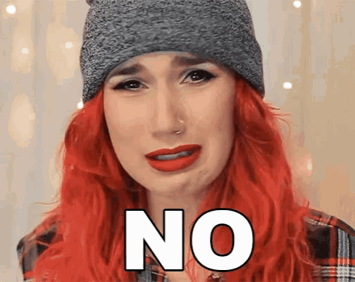 a woman with red hair is wearing a gray beanie and says no