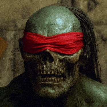 a statue of a skull with a red blindfold on his eyes
