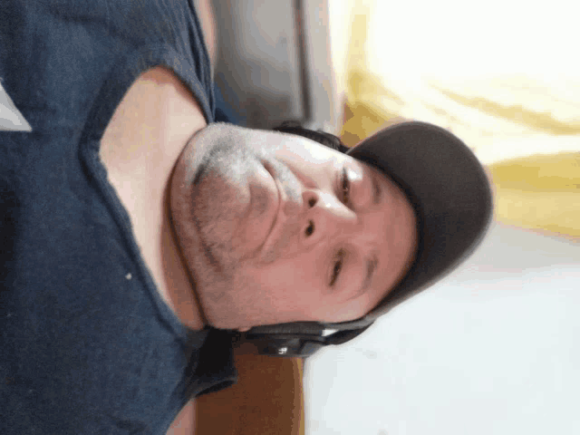 a man wearing headphones and a hat looks down at something