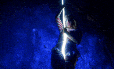 a woman in a red white and blue striped shirt is holding a light stick in front of a blue background