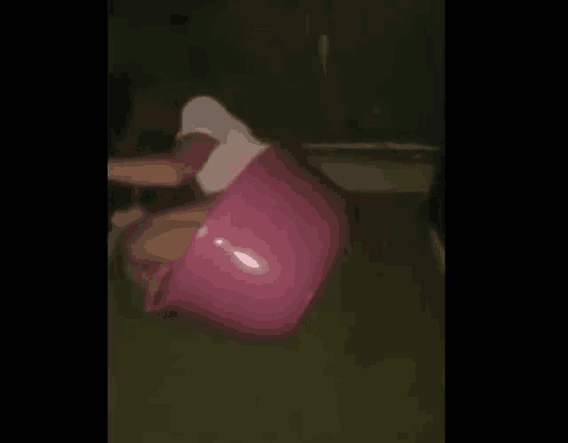 a woman is sitting in a pink bucket .