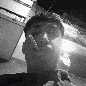 a black and white photo of a man smoking a cigar