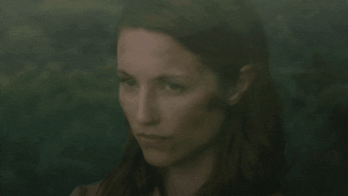 a close up of a woman 's face with red hair