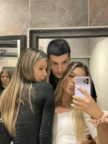 a girl taking a selfie with a man and another girl