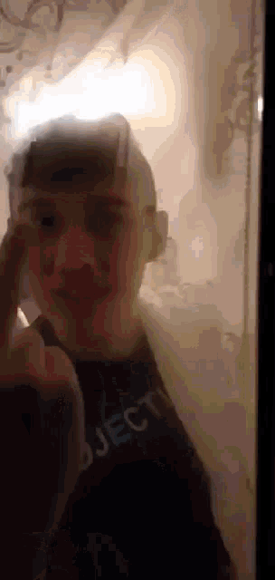 a young boy is taking a picture of himself in a bathroom .