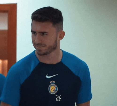 a man wearing a blue nike shirt with the number 6/1/2 on the front
