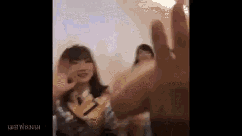 a close up of a person 's hand reaching out towards a girl .