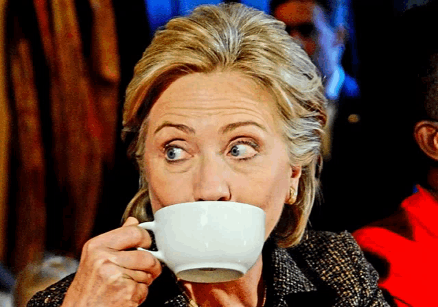hillary clinton drinking a cup of coffee with her eyes wide open