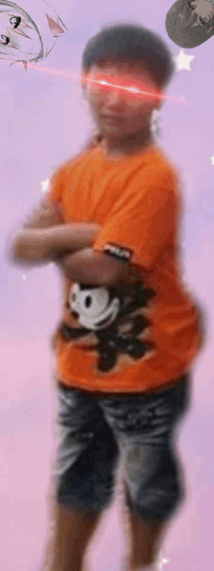 a young boy wearing an orange shirt with a monkey on it