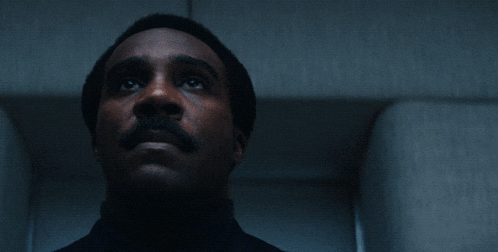 a man with a mustache is looking up and the word again is above him