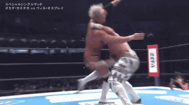 a wrestler is upside down in a wrestling ring with a sign that says nippon