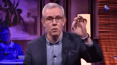 a man in a suit and glasses is on a television show